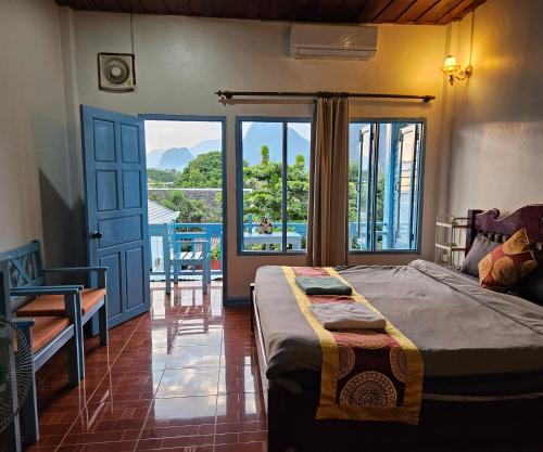 a bedroom with a bed and a view of a balcony at city mountain hotle in Vang Vieng