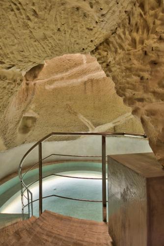 a swimming pool in a cave with a rock wall at Palazzo Consiglia - IK Collection in Valletta
