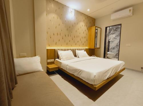 a bedroom with a large white bed and a window at Rukkmannie Holiday Inn in Ujjain