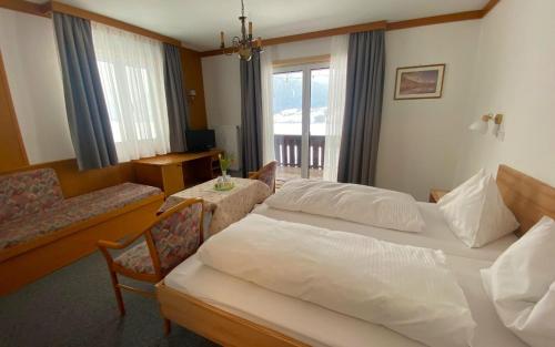 a hotel room with a bed and a couch and a table at Pension Max Schraml in Grundlsee