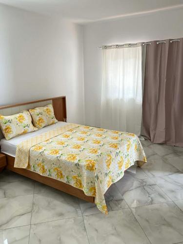 a bedroom with a bed with a floral comforter at Hotel Pirâmide in Igreja