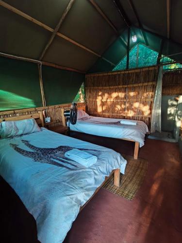 a bedroom with two beds in a tent at Amangwane Tented Camp in Kosi Bay