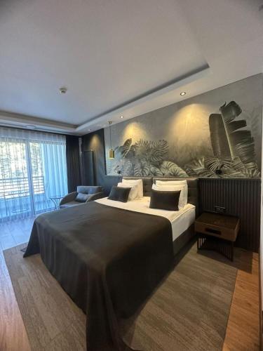 a bedroom with a large bed with a painting on the wall at Amorium Hotel in Kastamonu