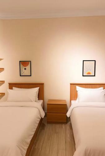 two beds sitting next to each other in a room at DEight by The Dream Stays in New cairo