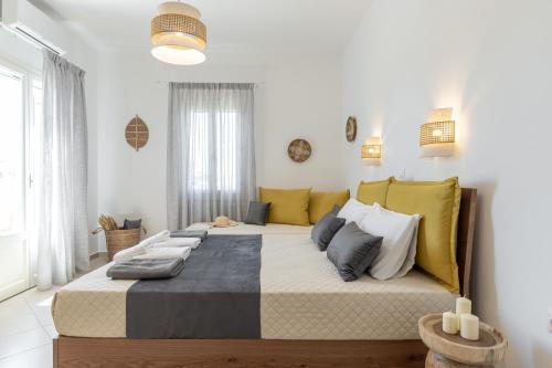a bedroom with a large bed with yellow and blue pillows at Sunshine in Naxos Chora