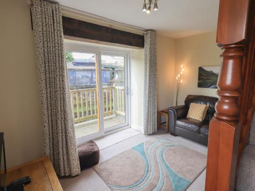 a living room with a couch and a large window at A River Runs By in Staveley