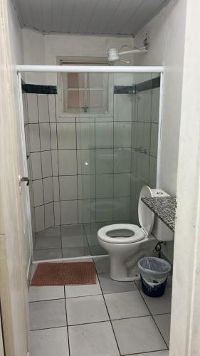 a small bathroom with a toilet and a shower at Casa Brasil pousada e lazer in Trindade