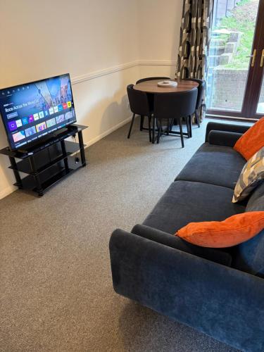 a living room with a couch and a flat screen tv at Home in Cwmbran with free onsite parking in Cwm-brân