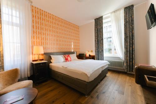 a bedroom with a bed and two windows at Villa Widder - Boutiquehotel in Staatsbad Brückenau