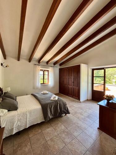 a bedroom with a bed in a room with wooden ceilings at Finca Es Puig, rustic estate with views in Es Carritxo