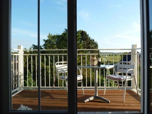 a balcony with a table and chairs on a deck at FeWo Leuchtturmblick in Kühlungsborn