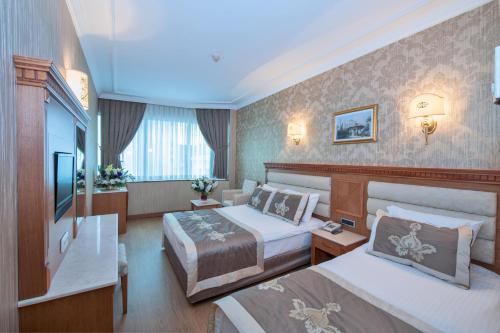 ein Hotelzimmer mit zwei Betten und einem Tisch in der Unterkunft Dalan Otel Istanbul Old City in Istanbul