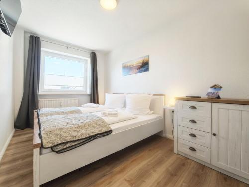 a bedroom with a white bed and a window at Sonne, Wind und Meer in Westerland