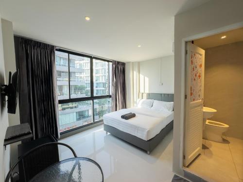 a bedroom with a bed and a large window at On The Six Studios Pratamnak in Pattaya South
