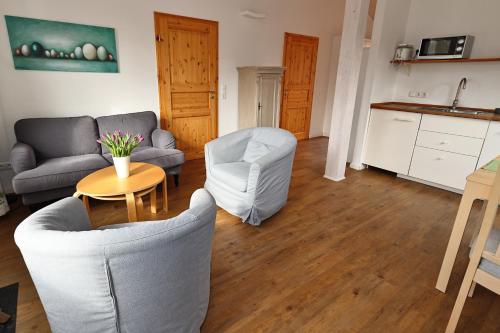 a living room with a couch and chairs and a table at Schwedenhaus Westensee 1 EG in Groß Vollstedt