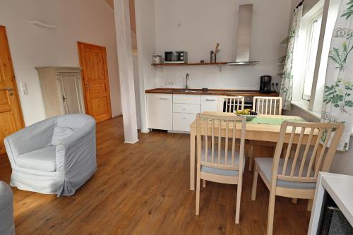 a kitchen with a wooden table and chairs and a table and chairsktop at Schwedenhaus Westensee 1 EG in Groß Vollstedt
