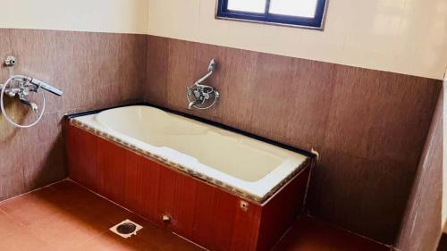 a bathroom with a bath tub in a room at Advaitha Serenity Resorts in Kālvādi