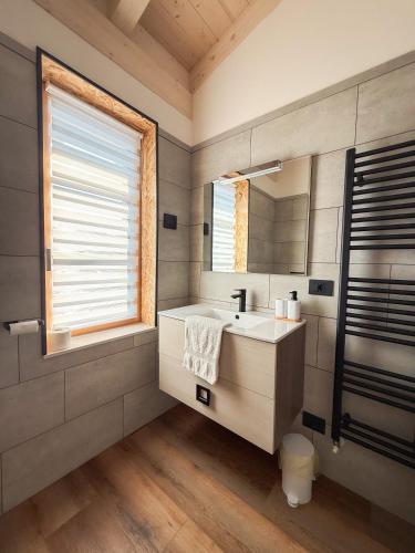 a bathroom with a sink and a mirror at Le Calle Holiday Apartments in Nago-Torbole