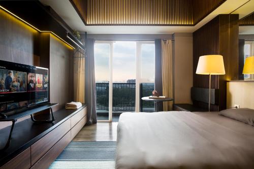 a bedroom with a large bed and a large window at Futura Studio-Modern Apartment near CBD BSD in Serpong