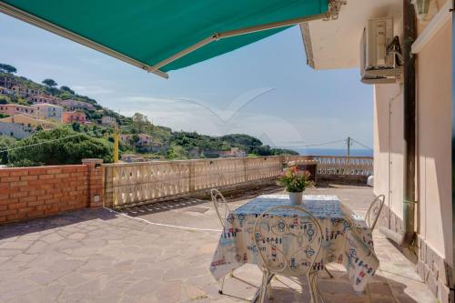 a table and chairs on a balcony with a view at Villa Flora - Goelba in Capoliveri