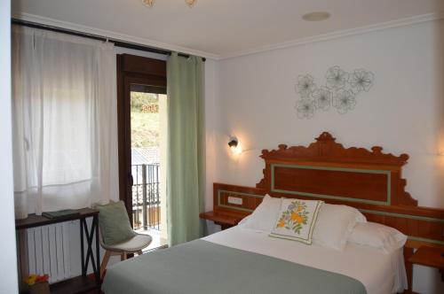 a bedroom with a bed and a window at Hotel El Jisu in Camaleño