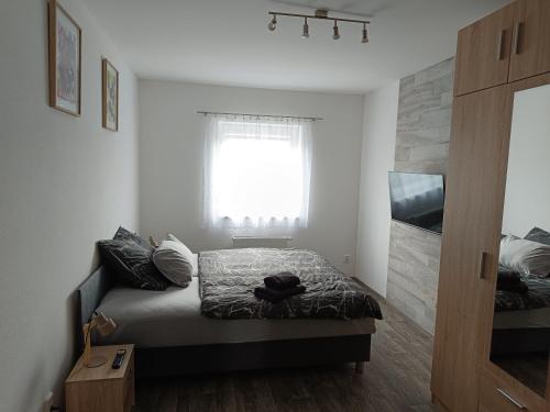 a small bedroom with a bed and a window at Apartmán Velký Luh in Velký Luh