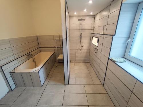 a bathroom with a tub and a shower and a sink at Ferienwohnung Alte Fleischerei in Lauchhammer