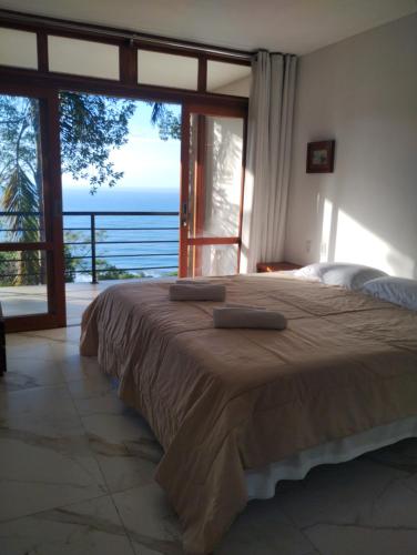 a bedroom with a bed with a view of the ocean at Pousada Samambaia in Paraty