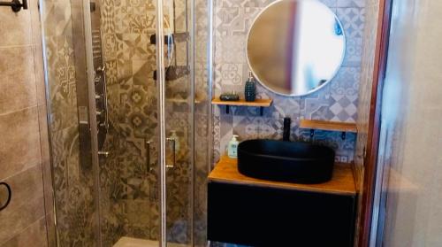 a bathroom with a shower with a sink and a mirror at Boho Chic Beach Resort in Sardegna in Porto Istana