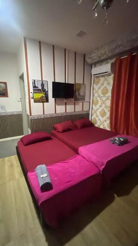 a bedroom with two beds with pink sheets at CZ CLASSIC in Pasir Puteh