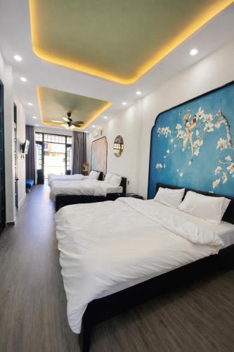 a hotel room with three beds and a blue wall at Victoria Villa 2 in Hue
