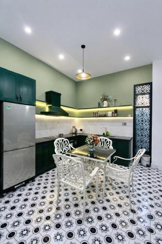 a kitchen with a table and two white chairs at Victoria Villa 2 in Hue
