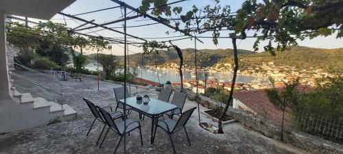 a table and chairs with a view of a city at Perioptron Guesthouse Ithaca in Vathi