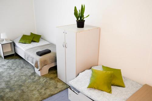 a bedroom with a bed and a cabinet with a plant on it at Hostel Września in Września