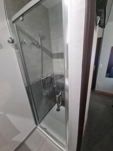 a glass door of a shower in a bathroom at Hôtel Relais des Vosges in Monthureux-sur-Saône