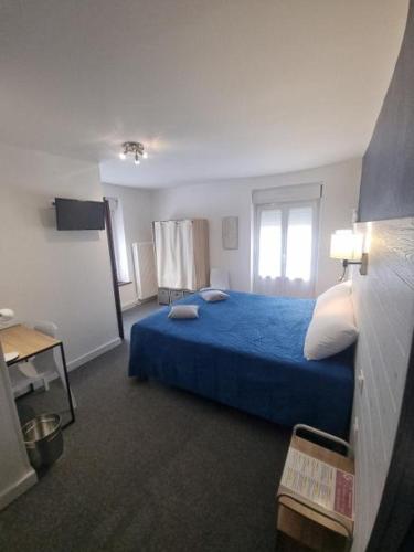 a bedroom with a blue bed and a window at Hôtel Relais des Vosges in Monthureux-sur-Saône