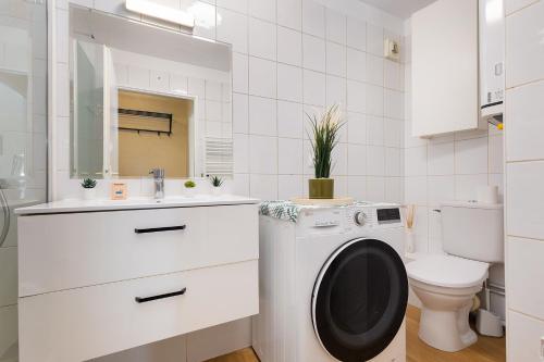 a white bathroom with a washing machine in it at Le Marnois-Gare in Noisy-le-Grand