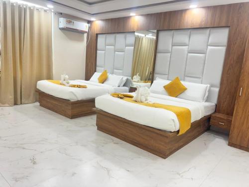 two beds in a hotel room with two bedsvisor at Surmila International Hotel in Āsansol