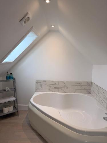 a white bath tub in a bathroom with a window at The Old Bank in Moffat