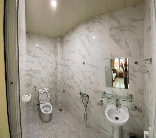a bathroom with a toilet and a sink at Khách sạn Tâm An in Ða Gia