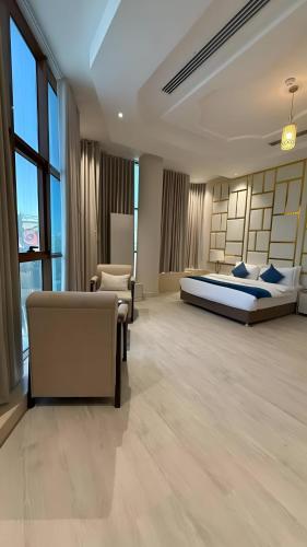 a bedroom with two beds and a couch and a chair at Lavera in Hotel - Rowibeh Hotels in Riyadh
