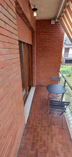 a patio with a table and chairs on a brick wall at MarcOrio Apartment in Orio al Serio