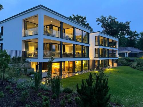 a large house with large glass windows at night at Apartment "Freya" - DECK9 Am Haff in Garz