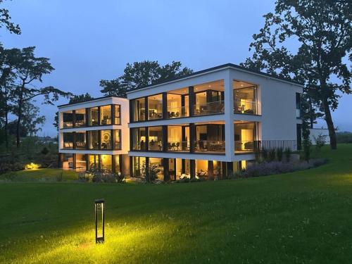 a large house with many windows on a lawn at Apartment "Alva" - DECK9 Am Haff in Garz