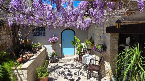 a house with purple wisterias hanging over the front door at The Courtyard Suite in Limassol