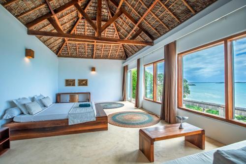 a bedroom with a bed and a view of the ocean at Mazava Loha Resort in Antsiranana