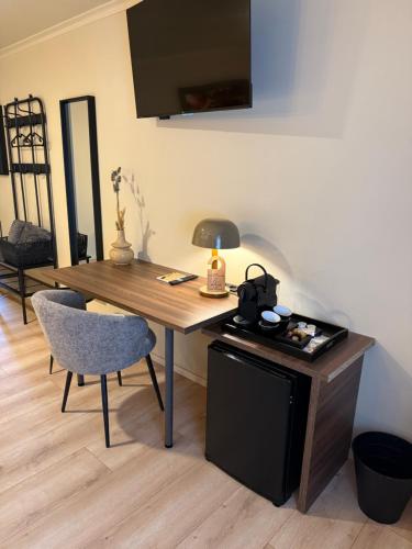 a wooden table with a chair and a lamp on it at Hotel Le Relais de Pommard in Francorchamps