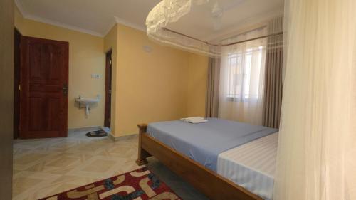 a bedroom with a bed and a bathroom at The Hidden Paradise in Mombasa