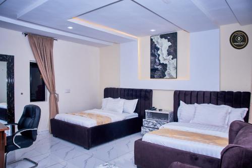 ein Hotelzimmer mit zwei Betten und einer Couch in der Unterkunft Ozigrand Hotel in Benin-Stadt