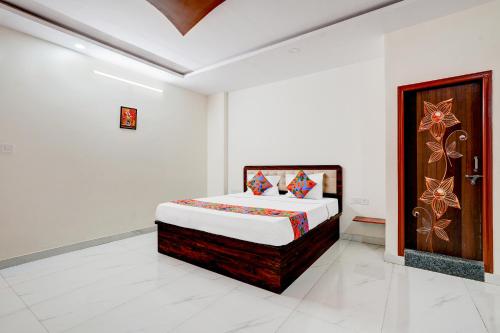 a bedroom with a bed and a wooden door at FabHotel Royal Garuda Palace in Bangalore